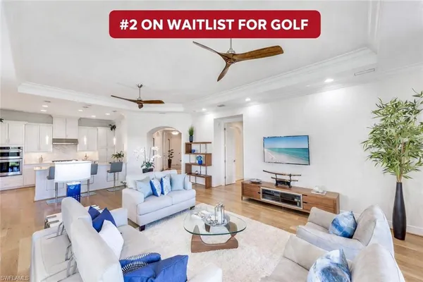 a living room with furniture kitchen view and a potted plant