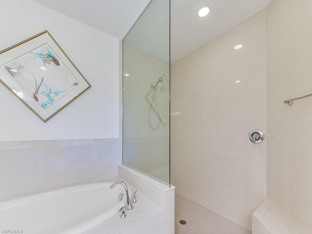 16425 Carrara Way, Unit 101 Naples, FL 34110 - Photo 16 of 21 a bathroom with a bathtub and a shower