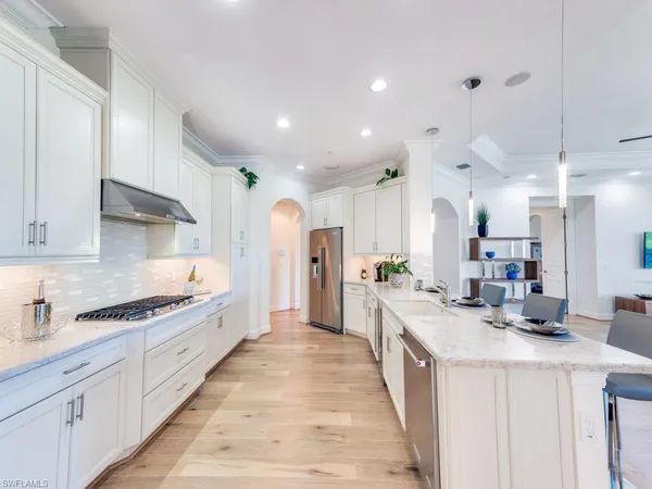 a kitchen with stainless steel appliances a sink stove and cabinets