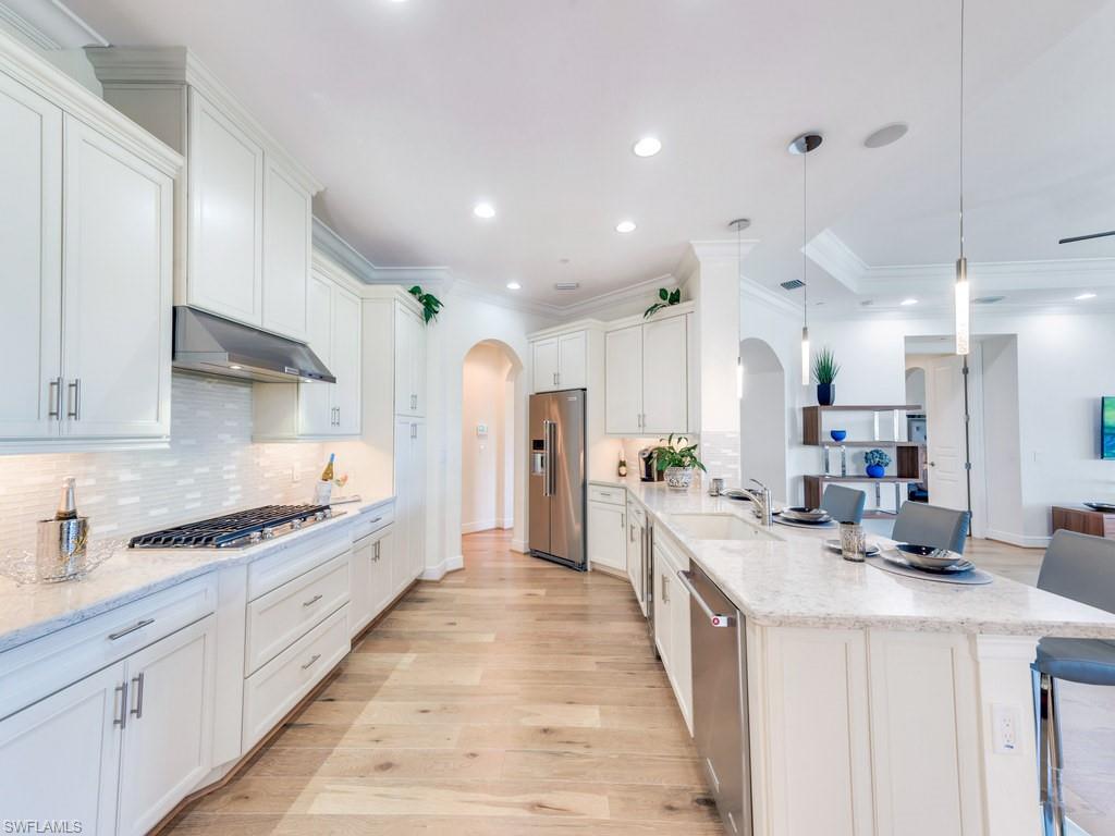 16425 Carrara Way, Unit 101 Naples, FL 34110 - Photo 7 of 21 a kitchen with stainless steel appliances a sink stove and cabinets