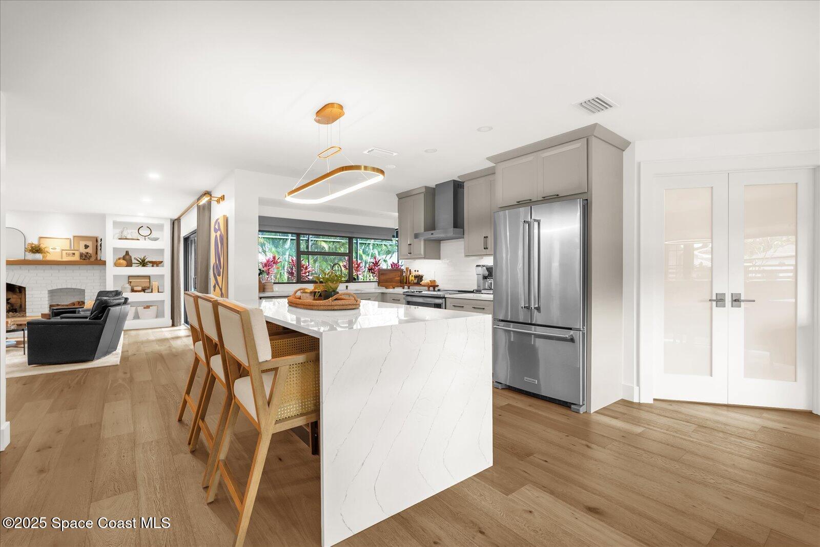 3204 Nottingham Lane Cocoa, FL 32926 - Photo 11 of 36 a kitchen with stainless steel appliances a refrigerator a stove a sink dishwasher and white cabinets with wooden floor