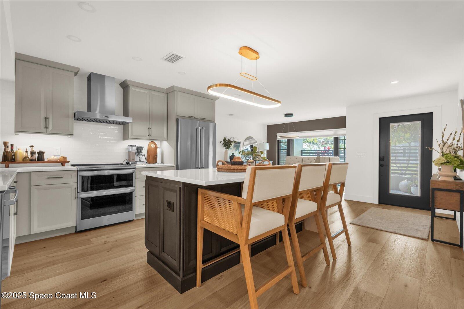 3204 Nottingham Lane Cocoa, FL 32926 - Photo 8 of 36 a kitchen with stainless steel appliances kitchen island granite countertop a table chairs stove and cabinets