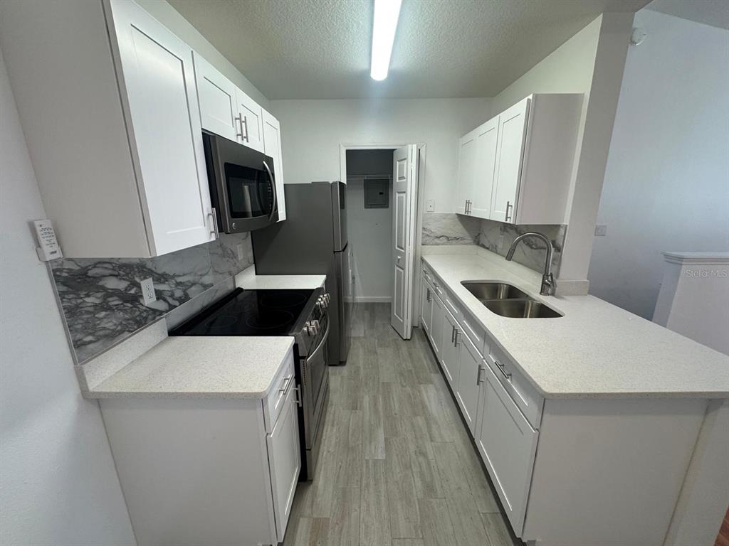 4320 South Kirkman Road, Unit 1508 Orlando, FL 32811 - Photo 11 of 25 a kitchen that has a sink and a stove in it