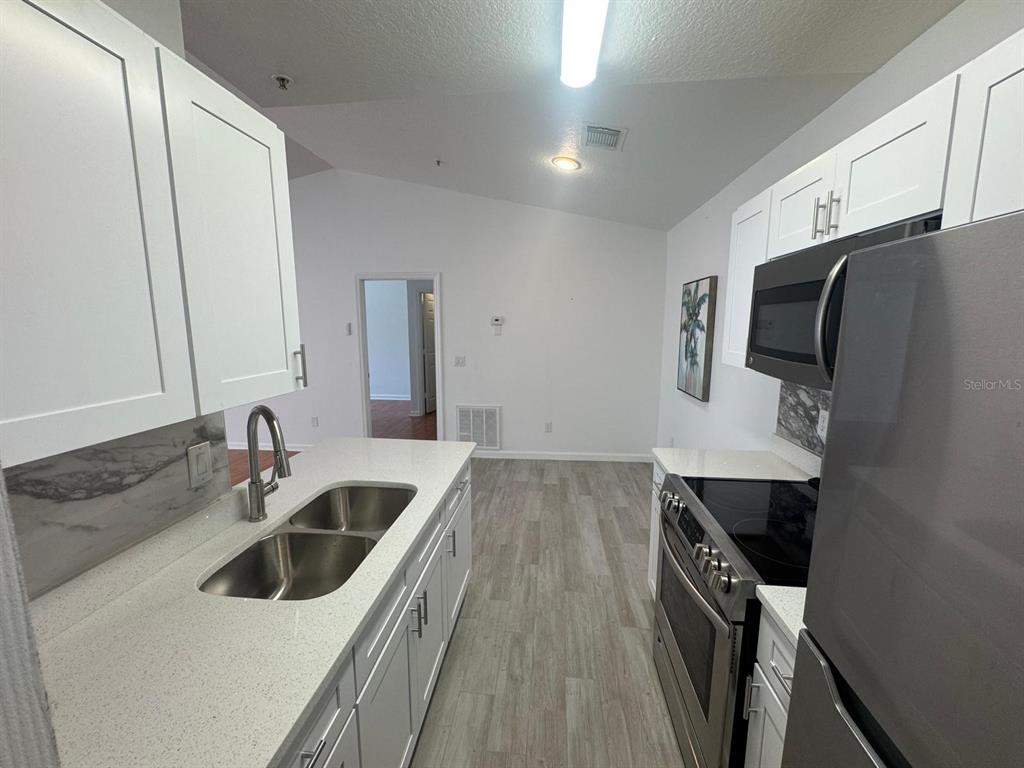 4320 South Kirkman Road, Unit 1508 Orlando, FL 32811 - Photo 12 of 25 a kitchen with a sink and refrigerator