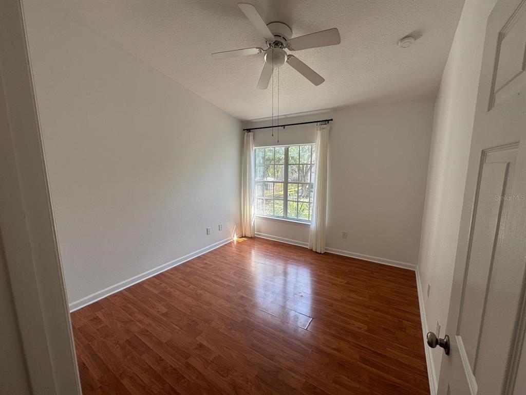 4320 South Kirkman Road, Unit 1508 Orlando, FL 32811 - Photo 13 of 25 an empty room with wooden floor fan and windows