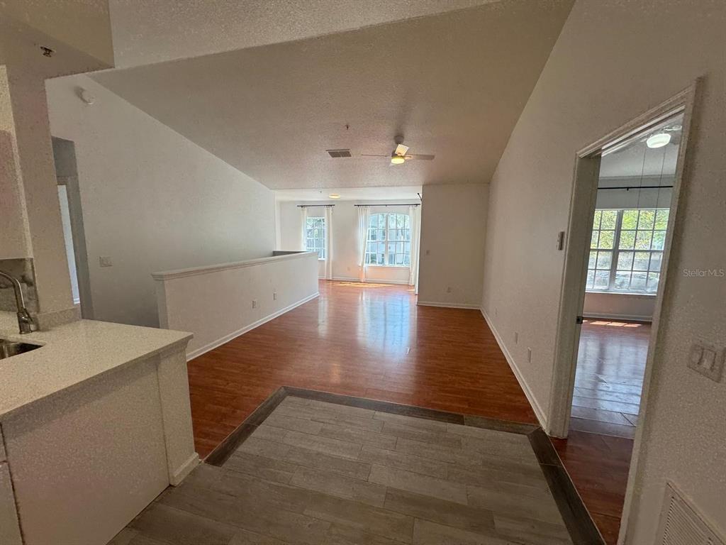 4320 South Kirkman Road, Unit 1508 Orlando, FL 32811 - Photo 5 of 25 a view of a hallway to an empty room with wooden floor and a window