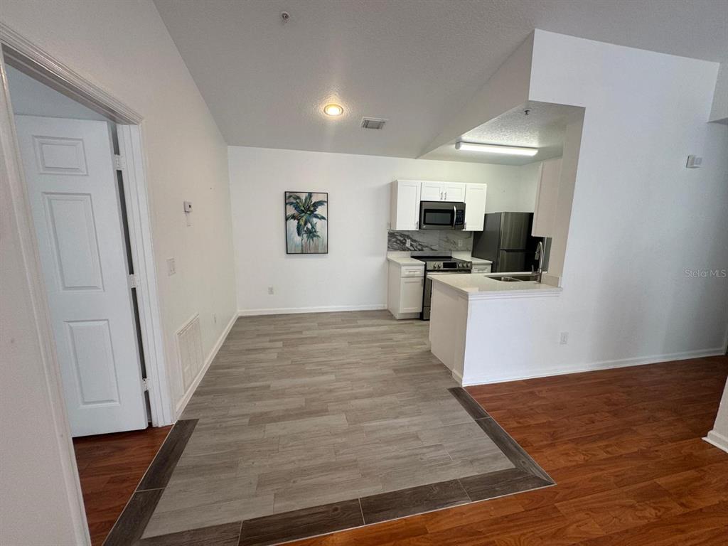 4320 South Kirkman Road, Unit 1508 Orlando, FL 32811 - Photo 9 of 25 a view of a kitchen with wooden floor and electronic appliances