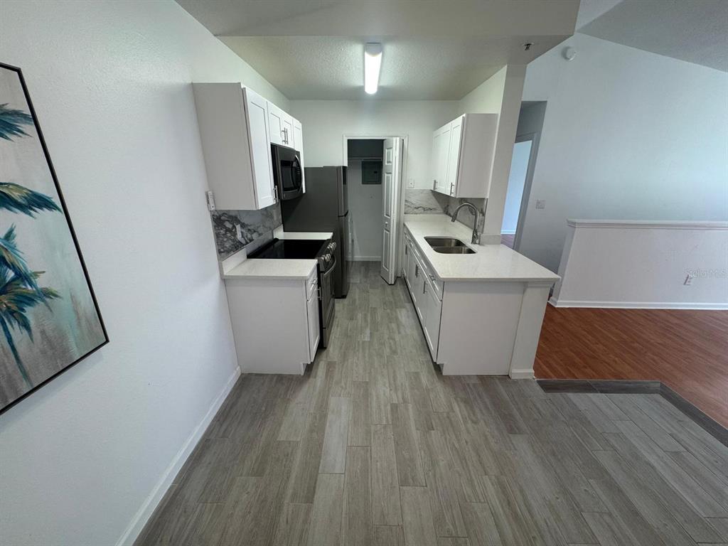 4320 South Kirkman Road, Unit 1508 Orlando, FL 32811 - Photo 10 of 25 a room with wooden floor and white appliances