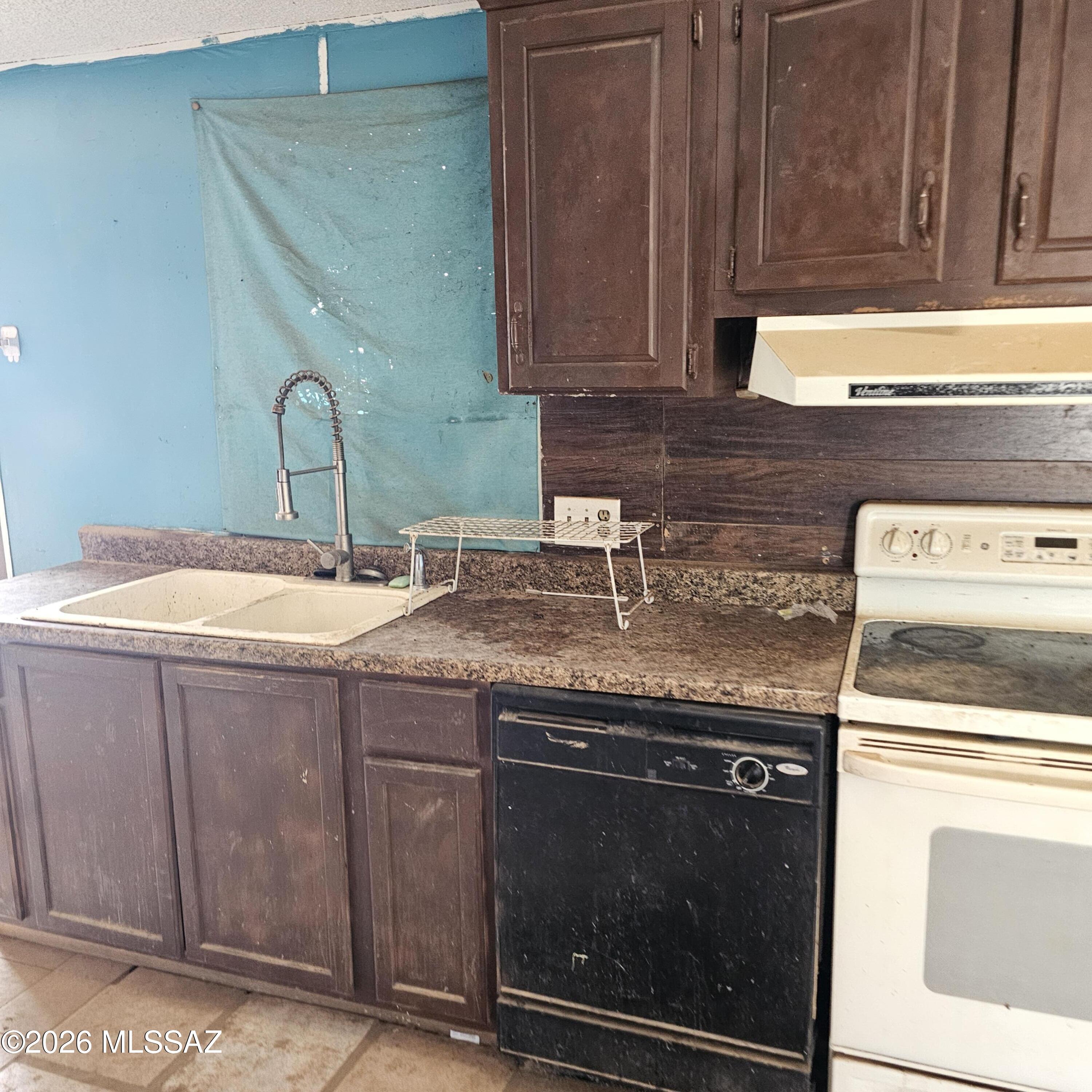 14020 West Park Road Tucson, AZ 85735 - Photo 4 of 18 a sink with granite countertop cabinets and a stove top oven