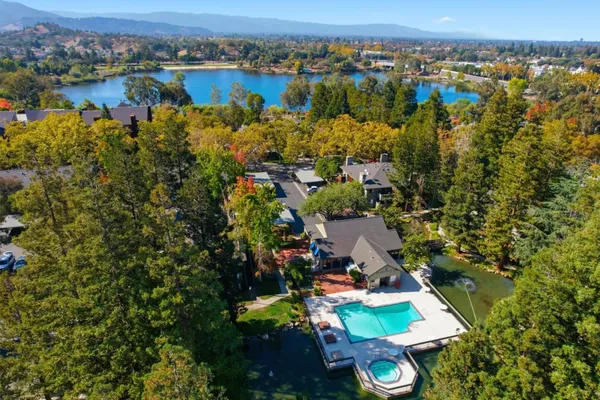 an aerial view of residential houses with outdoor space and lake view