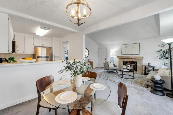 a view of a dining room with furniture a fireplace and wooden floor