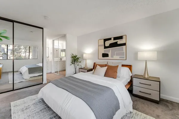 a bedroom with a large bed and a night stand