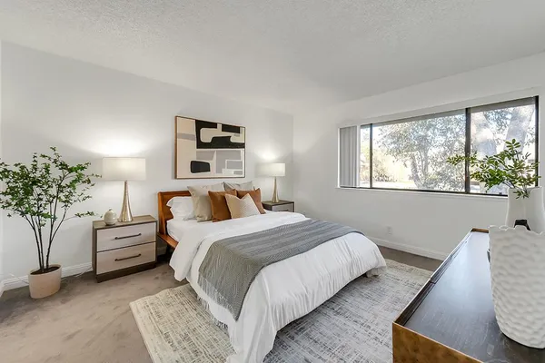 a bedroom with bed and a potted plant