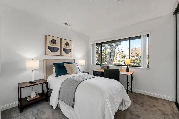 a bedroom with a bed and a large window