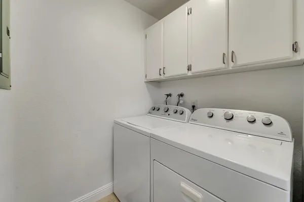 a utility room with dryer and cabinets