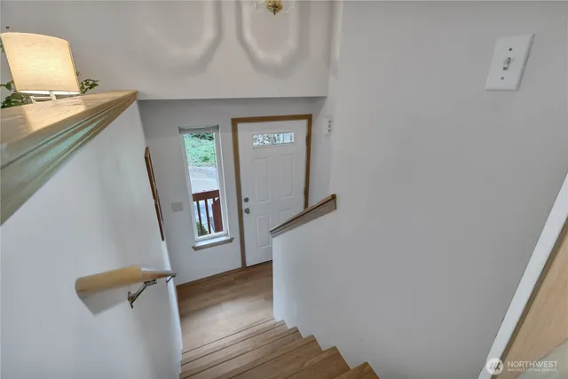 a view of a hallway with wooden floor and stairs