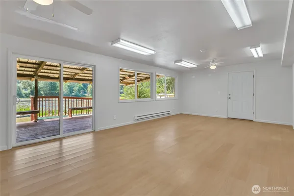 an empty room with wooden floor and windows