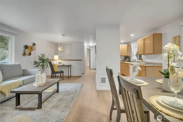 a living room with furniture and a dining table with kitchen view