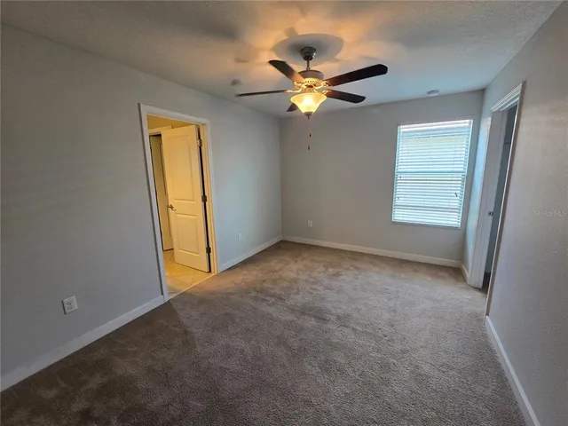 a view of a livingroom with a ceiling fan and window