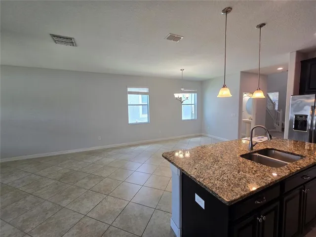 a kitchen with granite countertop a sink cabinets and wooden floor