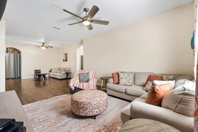 a kitchen with stainless steel appliances granite countertop a stove top oven a sink a dining table and chairs with wooden floor