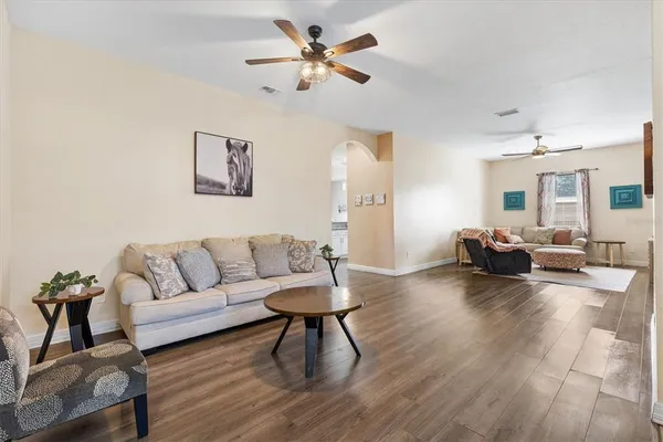 a living room with furniture and a wooden floor