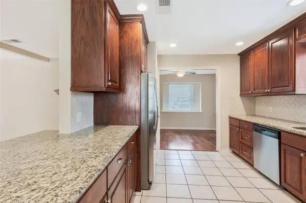 a kitchen with granite countertop a sink a stove and cabinets
