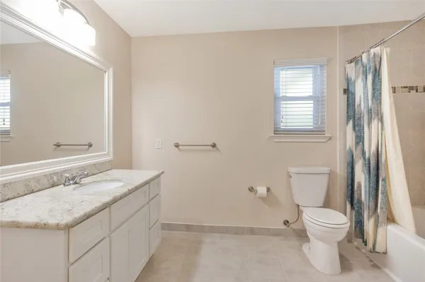 a bathroom with a granite countertop sink toilet and a mirror