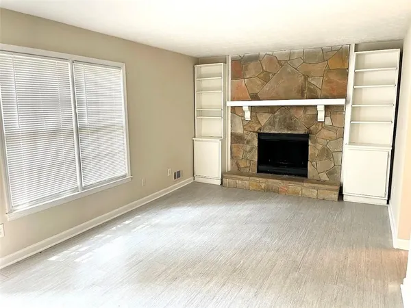 a view of empty room with window and fireplace