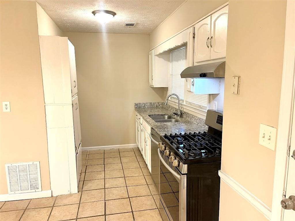 2611 Golfview Terrace Southeast Conyers, GA 30013 - Photo 6 of 22 a kitchen with stainless steel appliances granite countertop a stove and a refrigerator