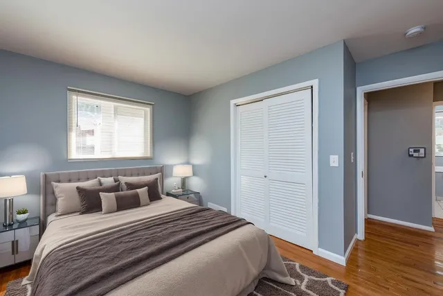 a bedroom with a bed and wooden floor