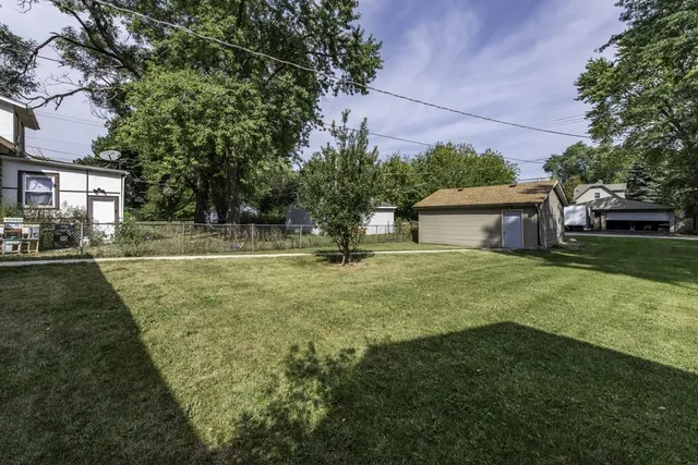 a view of a house with backyard and trees