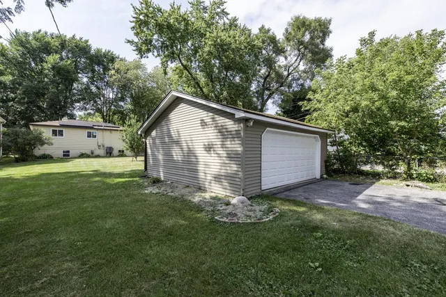 a view of backyard with large tree and wooden fence
