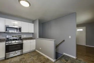 a kitchen with granite countertop a sink cabinets and stainless steel appliances