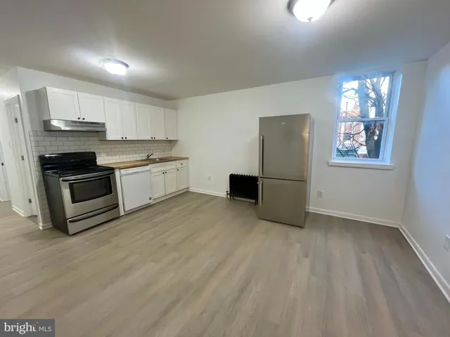 a view of kitchen with refrigerator stove microwave and cabinets