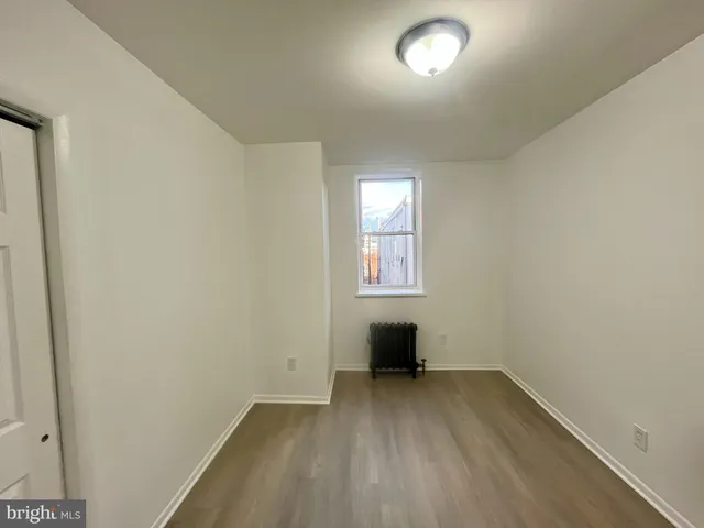an empty room with a window and a hallway