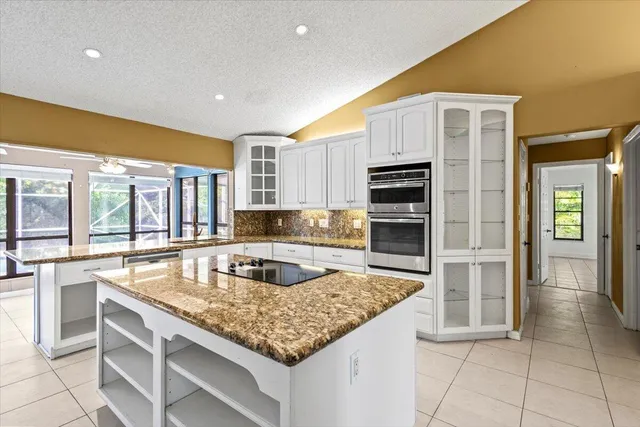 a kitchen with kitchen island granite countertop a stove and a sink