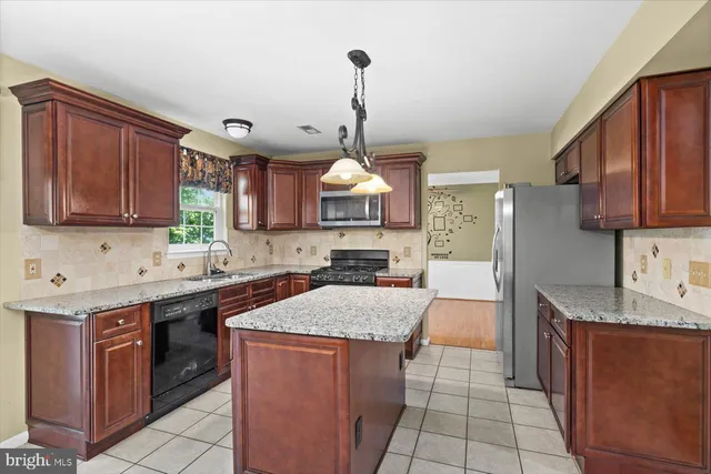 a kitchen with stainless steel appliances granite countertop a stove a sink dishwasher and a refrigerator