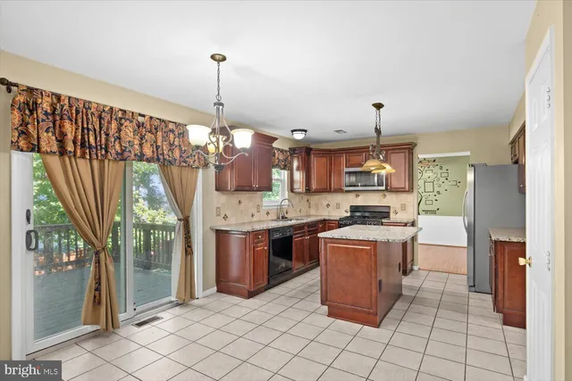 a kitchen with stainless steel appliances granite countertop a stove a sink dishwasher and a refrigerator