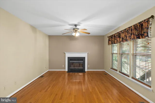 a view of a livingroom with wooden floor and a ceiling fan