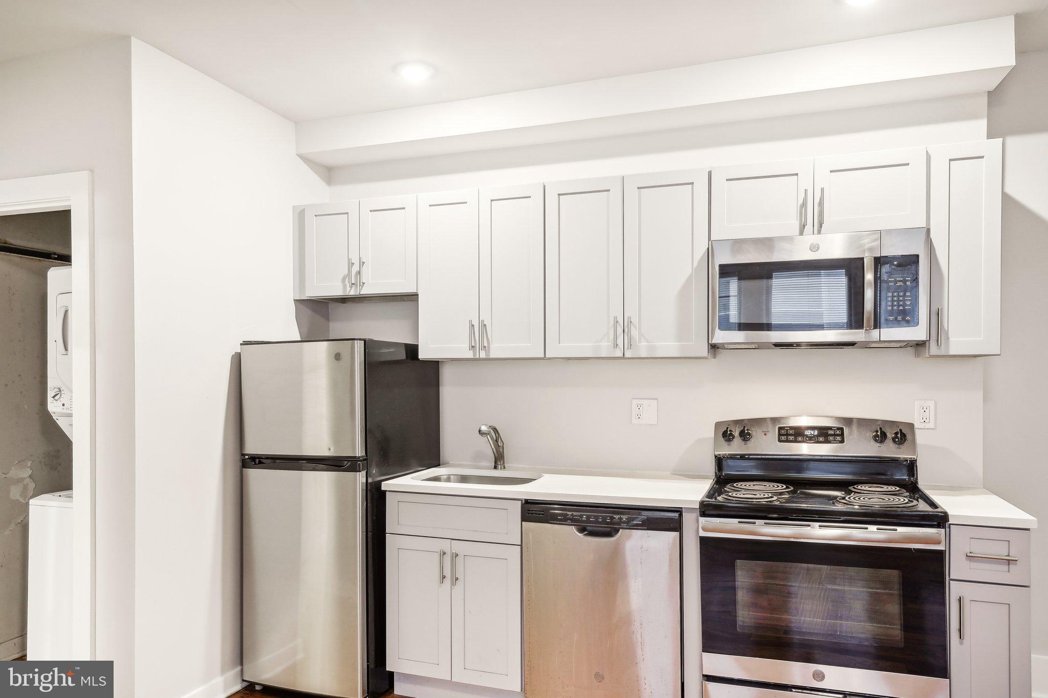 a kitchen with appliances a refrigerator and cabinets