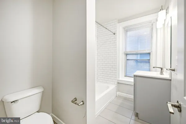 a bathroom with a granite countertop toilet sink and mirror