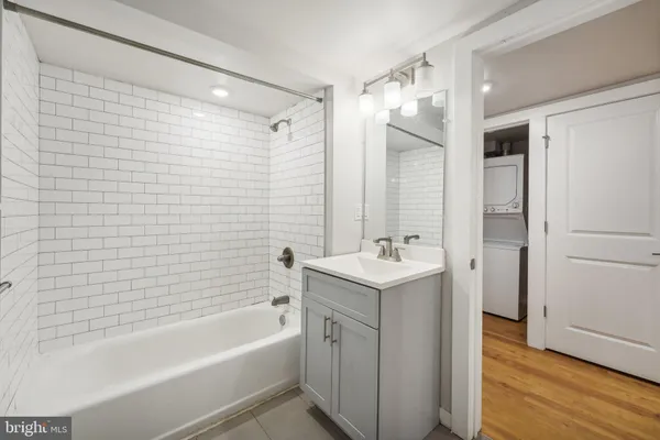 a bathroom with a tub sink shower and two mirror