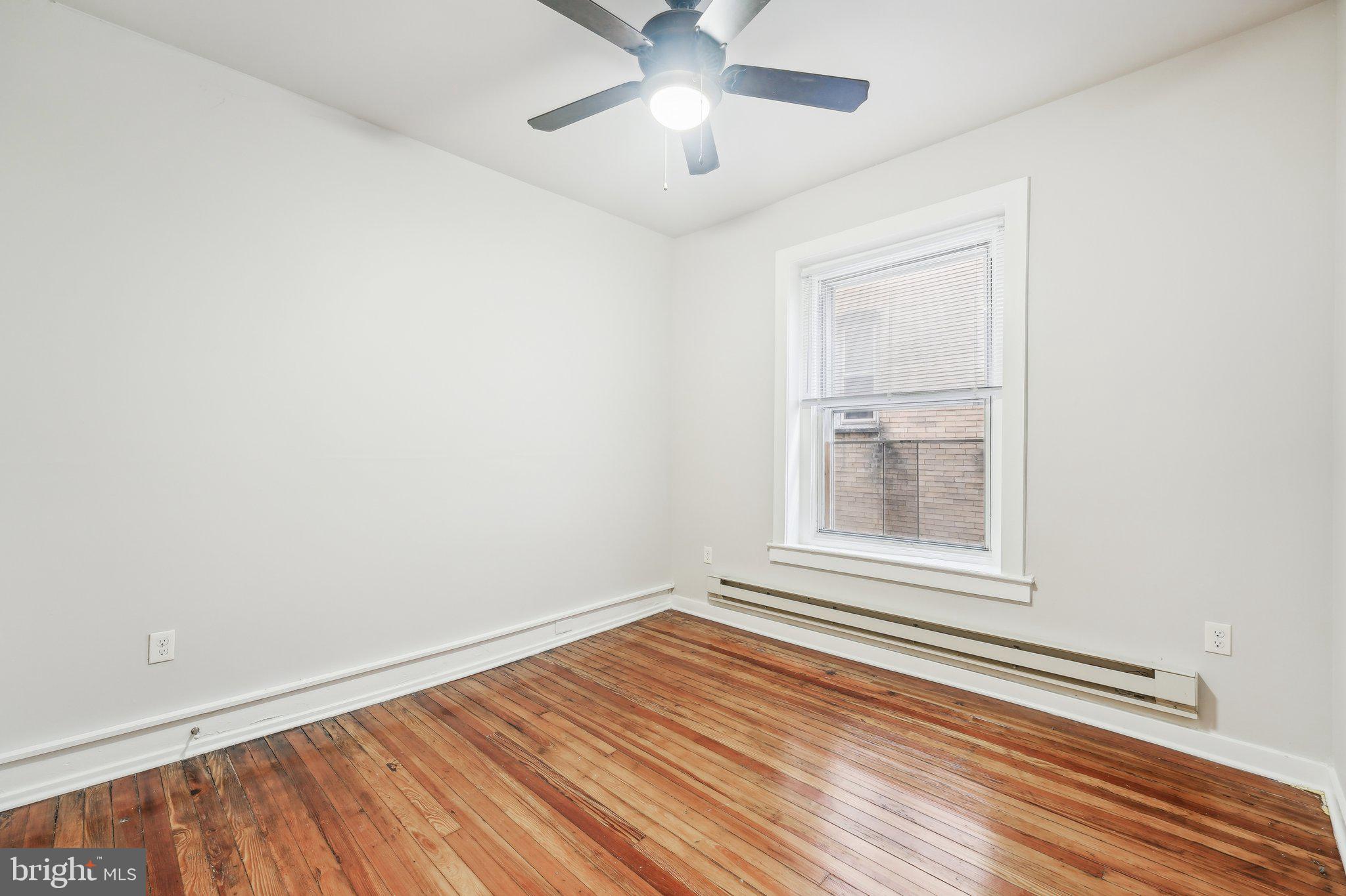 4300 Chestnut Street, Unit 2 Philadelphia, PA 19104 - Photo 17 of 30 an empty room with wooden floor chandelier fan and windows