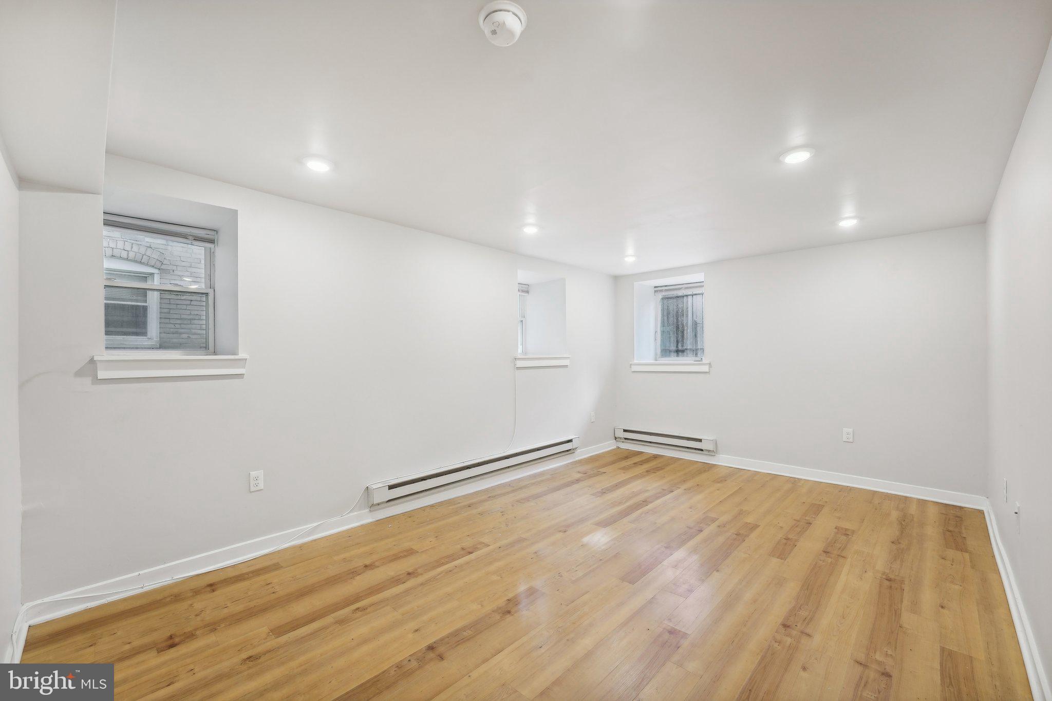 4300 Chestnut Street, Unit 2 Philadelphia, PA 19104 - Photo 19 of 30 a view of an empty room with wooden floor and a window