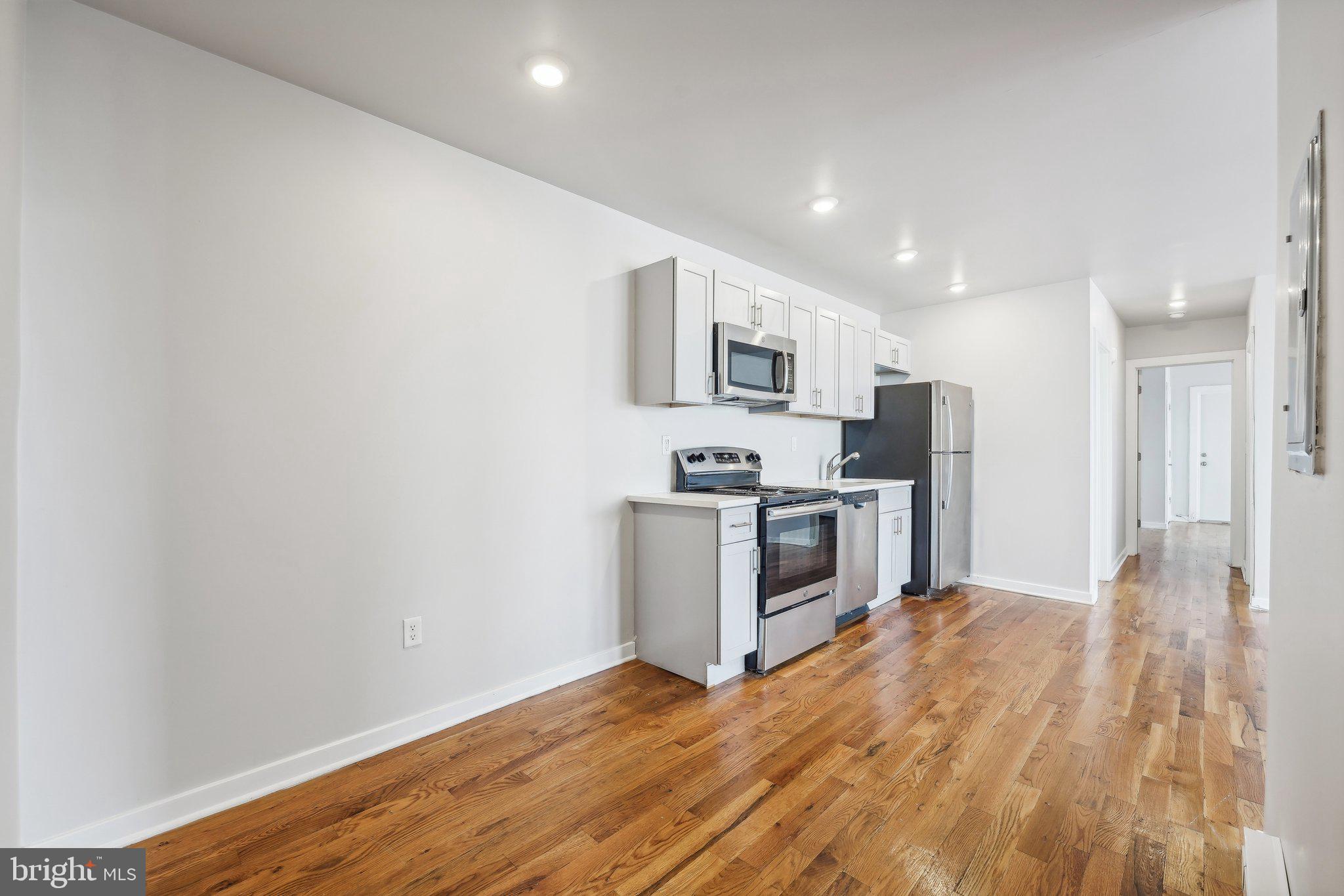 4300 Chestnut Street, Unit 2 Philadelphia, PA 19104 - Photo 6 of 30 a kitchen with stainless steel appliances a white refrigerator a stove top oven a sink and dishwasher