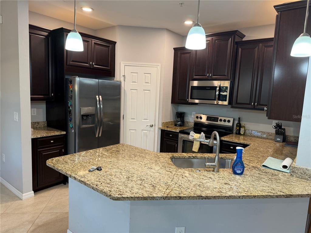 80 Navigation Circle Osprey, FL 34229 - Photo 11 of 36 a kitchen with stainless steel appliances granite countertop a sink refrigerator and microwave