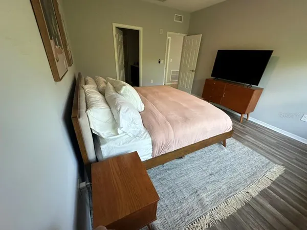 a bedroom with a bed and wooden floor