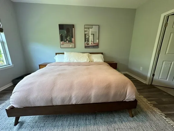 a large bed sitting in a bedroom next to a window