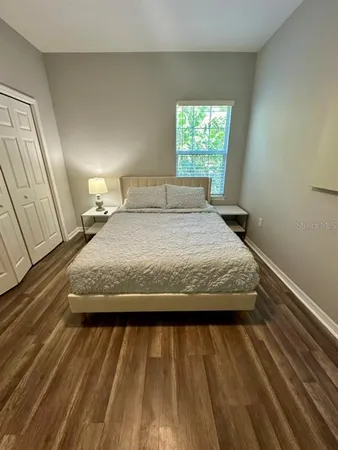 a bedroom with a bed and wooden floor
